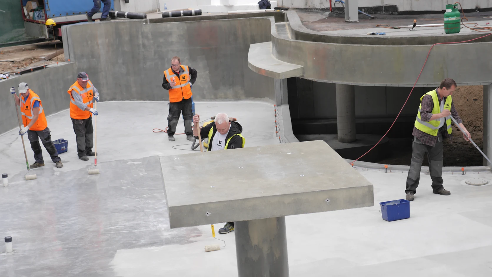A team preparing the substrate of a concrete basin.